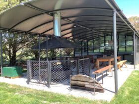 Communal area with firepit, banquet seating and BBQ
