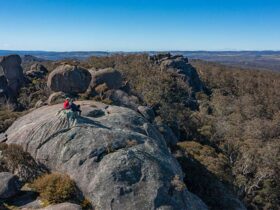 2 hikers sitting at the summit of Cathedral Rock, Cathedral Rock National Park. Photo: Josh Smith