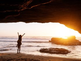 A couple embracing the sunrise inside a beach cave