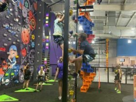 two boys race each other up the rock climbing walls