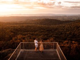 Drone photo of Yambla Lookout taken at sunset with a couple standing on the platform looking out.
