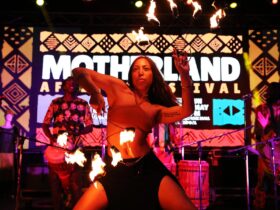 Fire juggling woman dancing on colourful stage