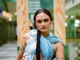 Artist Komang poses in the foyer of a shopping centre wearing a blue dress