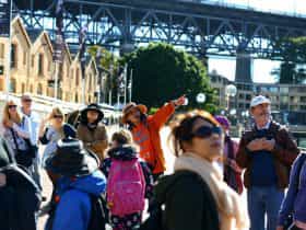 Free walking tours guide is explaining the history of Sydney to tourists