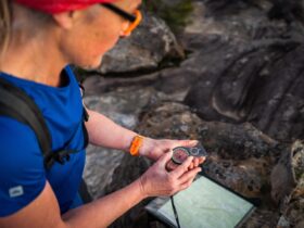 Woman adjusts compass with topographic map in background