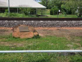 Memorial in the foreground, new railway line and historic station in the background.