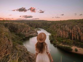 Girl standing on the edge of a weaving escarpment in Katherine Gorge at sunset