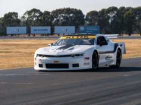 White TA2 Muscle Car racing along a racetrack