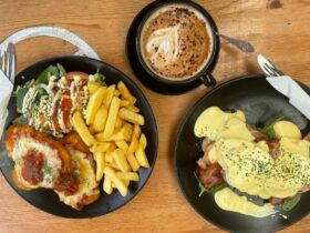 Chicken schnitzel with chips and salad, coffee and eggs Benny with bacon