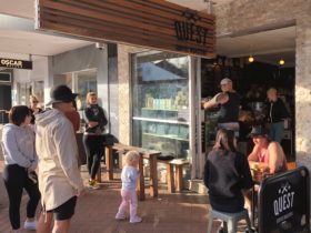 People awaiting drink and food orders at Quest Burleigh Cafe