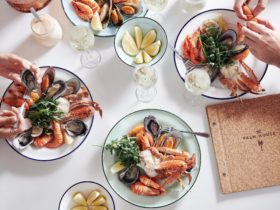 Various plates of seafood dishes on a white table