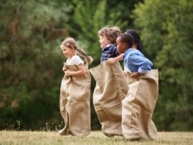Three children in hessian sacks jumping
