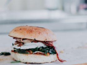 a toasted bread roll, filled with crispy bacon, a fried egg and spinach
