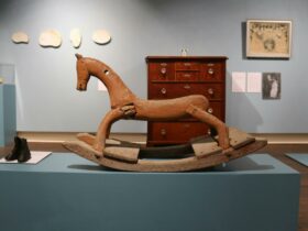 Old wooden Rocking horse on blue plinth in blue exhibition room