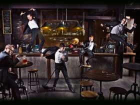 A group of dancers in tuxedos are in various positions in a bar
