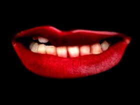 A set of teeth and red lips isolated on a black background