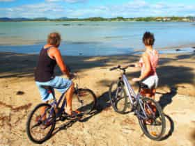 Two people on the beach with their bikes