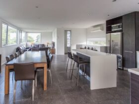 Kitchen, meals area showing ultra modern kitchen, timber table with seating for 8. Slate floors.