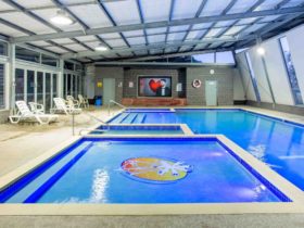 Indoor heated pool complex with giant TV screen