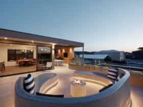 Luxury Exclusive Penthouse balcony entertaining area with seating and fireplace
