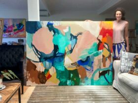 Artist Belinda Stone standing next to a large piece of art