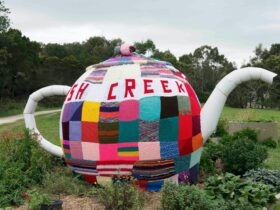 Knitted tea cosy on a big teapot in the Fish Creek Commmunity Garden
