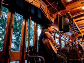 Musician playing a guitar on board the Groove Tram