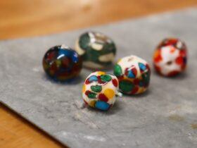 five spotted lampwork glass beads on a tray made by a studentlass
