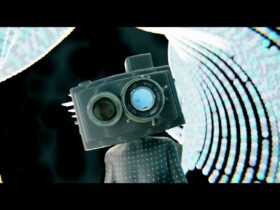 Animated character with a camera for a head, surrounded by white and blue lights