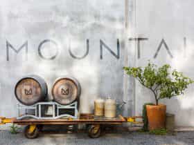Branding piece, photo of the front of the cellar door with barrels, lemon tree and the word MOUNTAIN