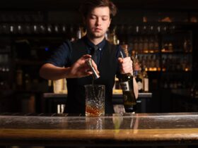 Cocktail bar and a bartender pouring a drink in a glass