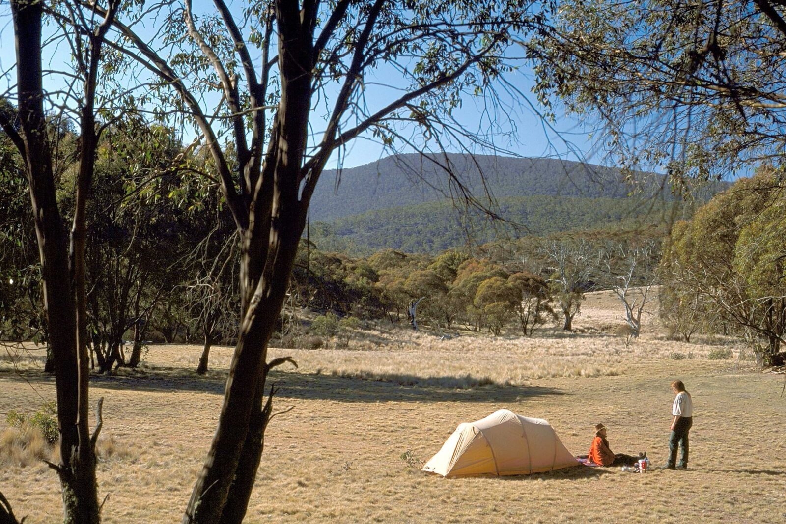 Photo of landscape with tent and two people in distance