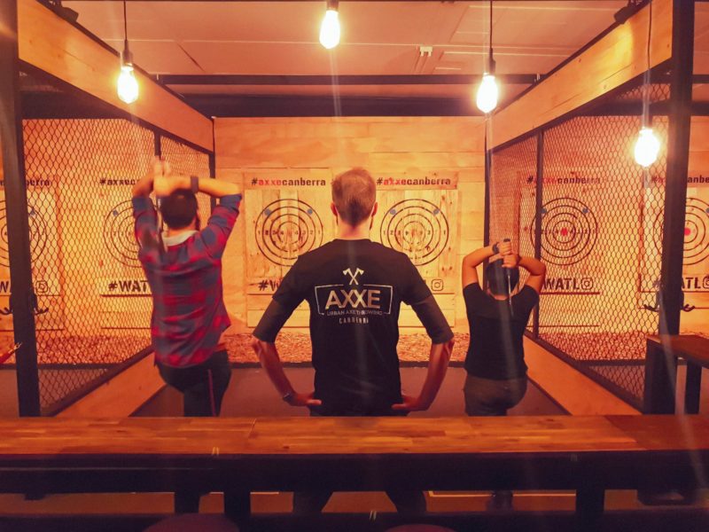 Two people throwing axes at targets