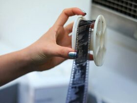 A photograph of a hand taking film off of a film reel