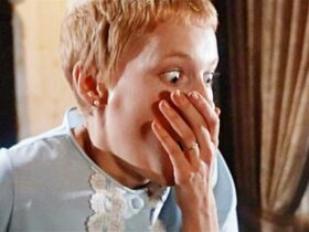 Still from Rosemary's Baby showing a woman covering her mouth in shock
