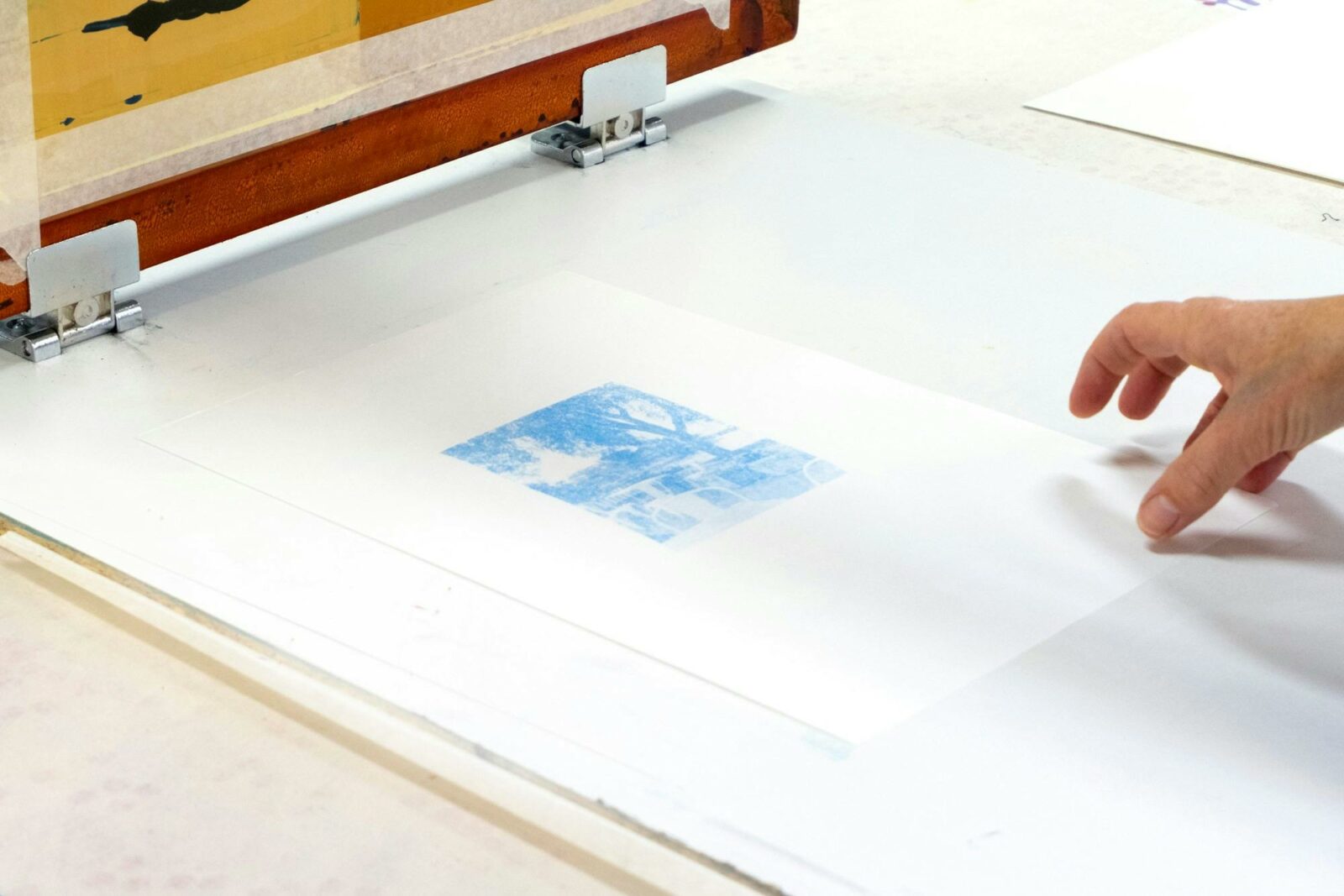 A photograph of a hand touching a screenprint