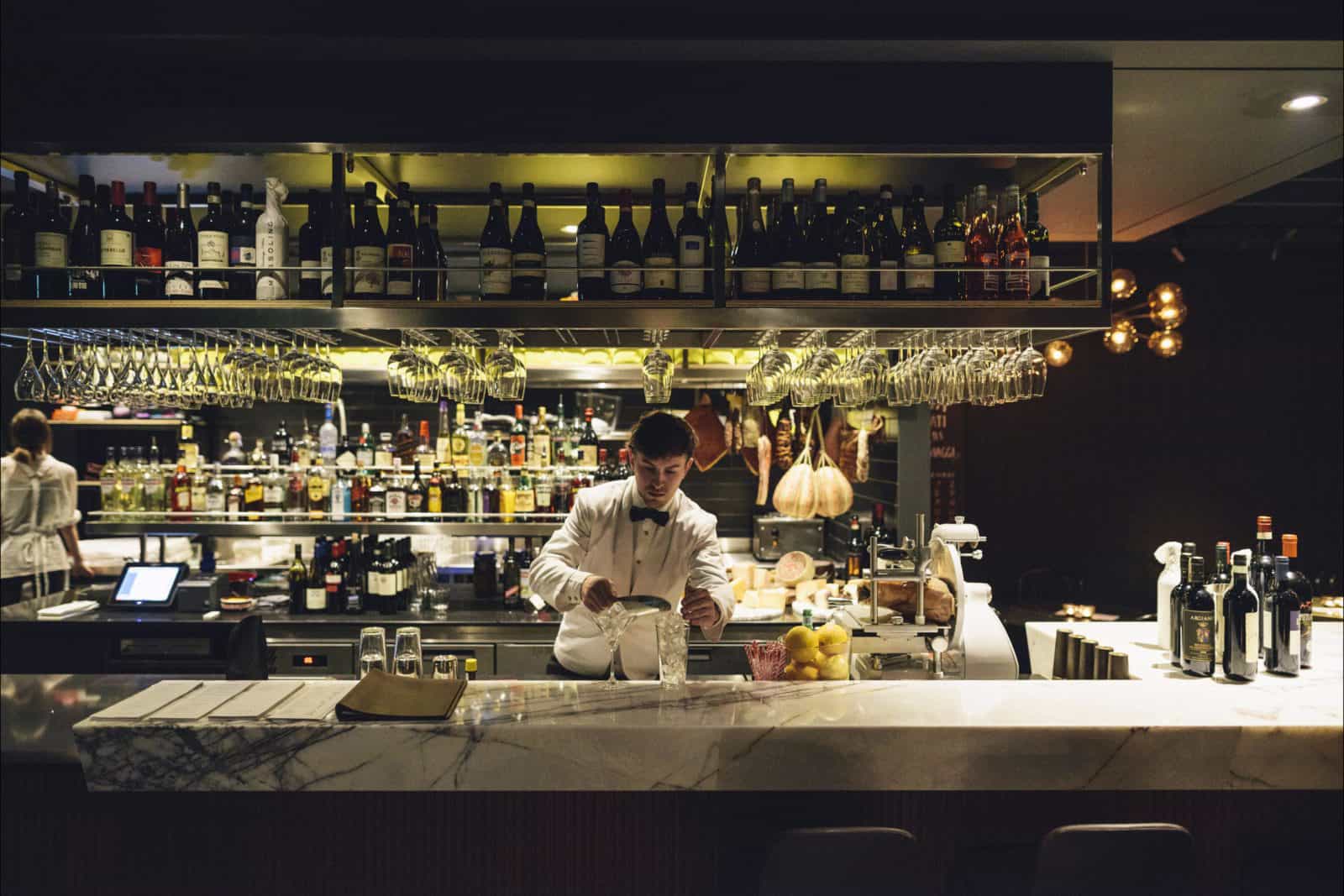 Barman pouring drinks at a marble bar