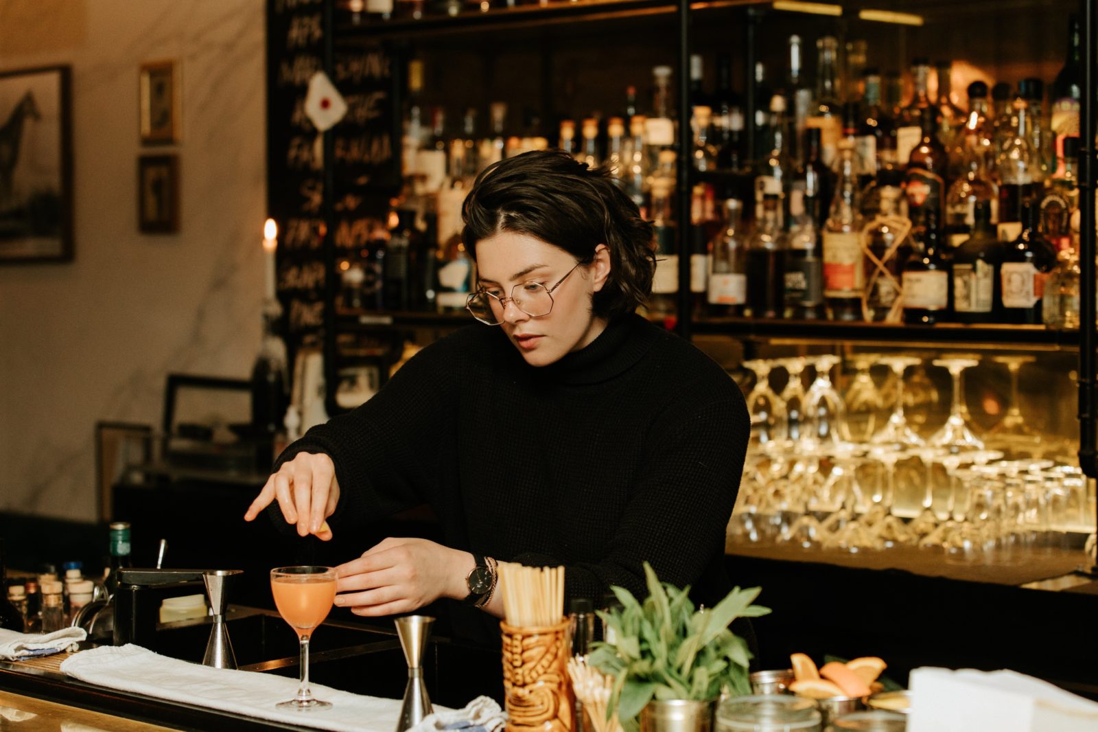 Person making a cocktail at a bar