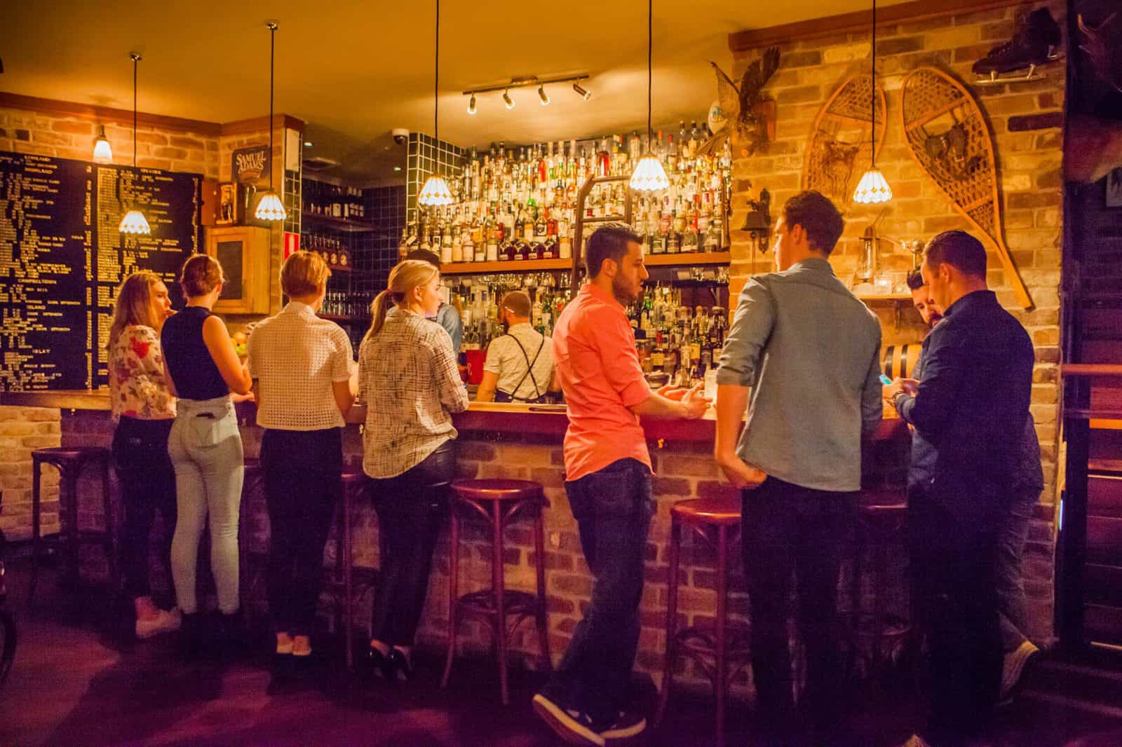 Young people lined up at the bar for cocktails