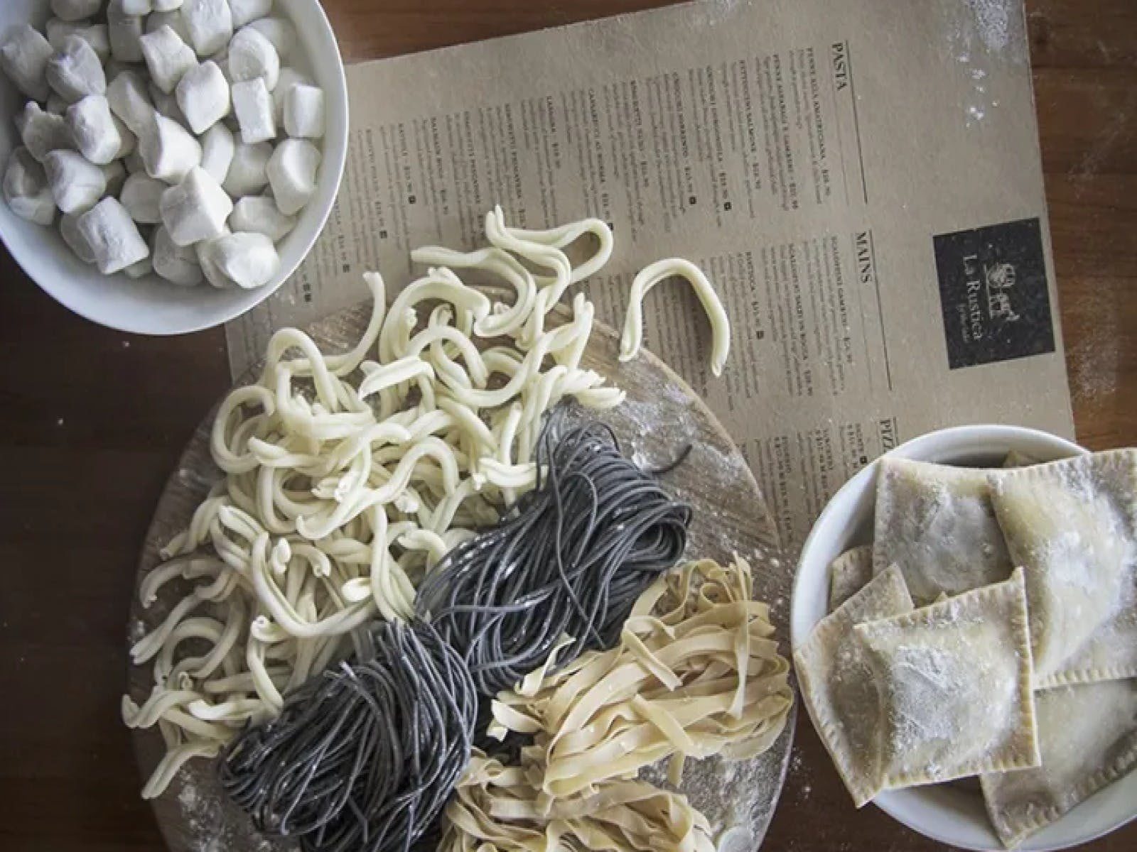 Some fresh pasta next to a menu on a table