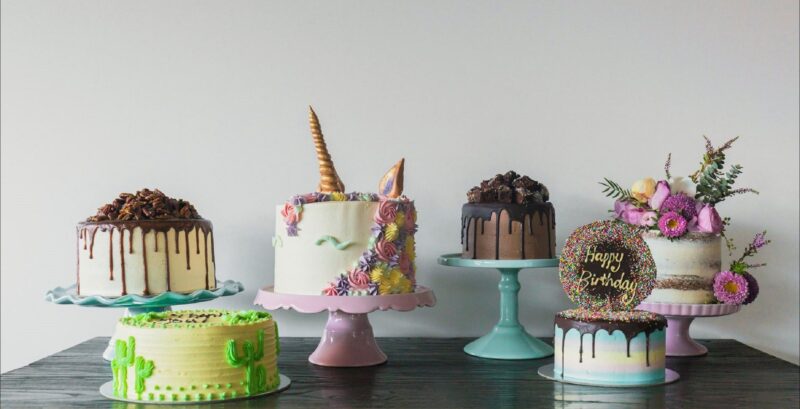 Line of decorated cakes of all colours and shapes.