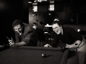 People laughing playing pool at bar