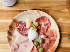 Antipasto platter on wooden table with bottle of wine