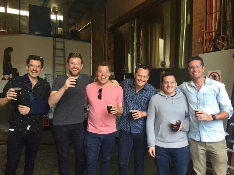 Happy men with beers on a brewery tour
