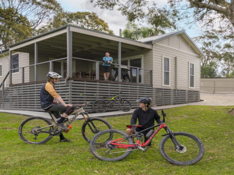 Guests on bikes in front of Baileys Cottage. Photo: John Spencer © DPE