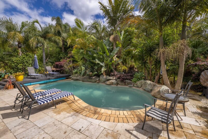 The heated pool is surrounded by lush gardens