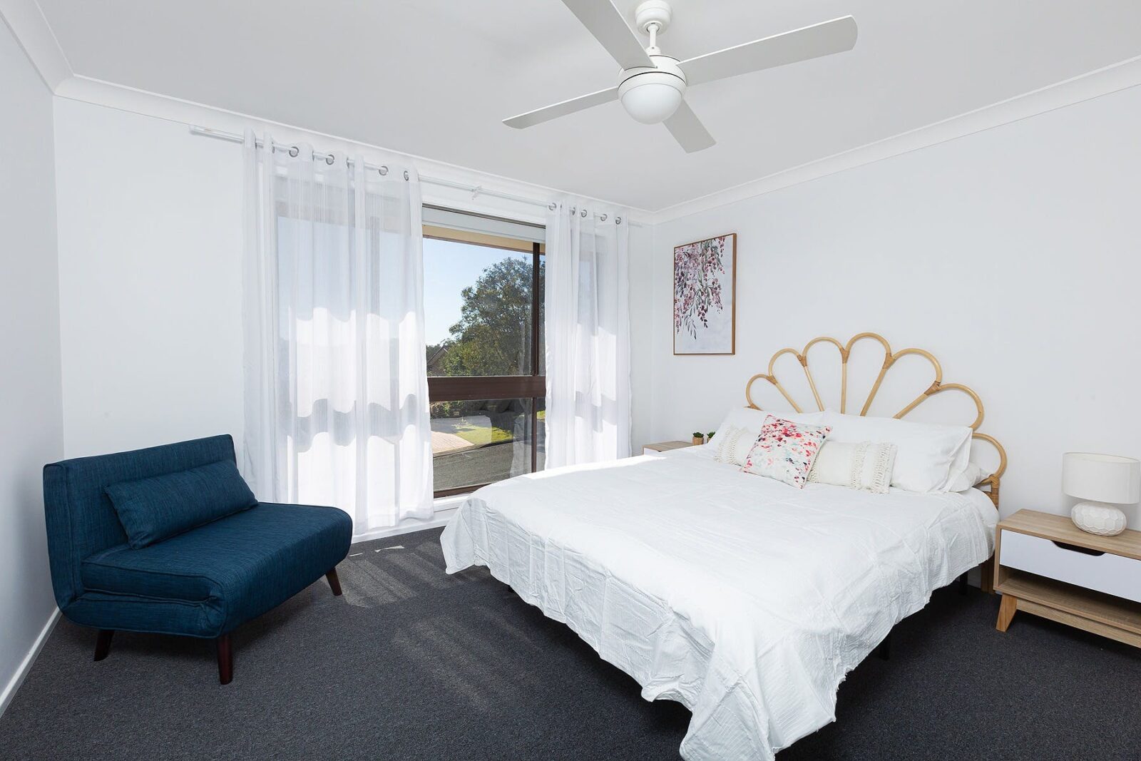 Main bedroom with Queen with stylish rattan bedhead, air-conditioning, ceiling fan, occasional chair