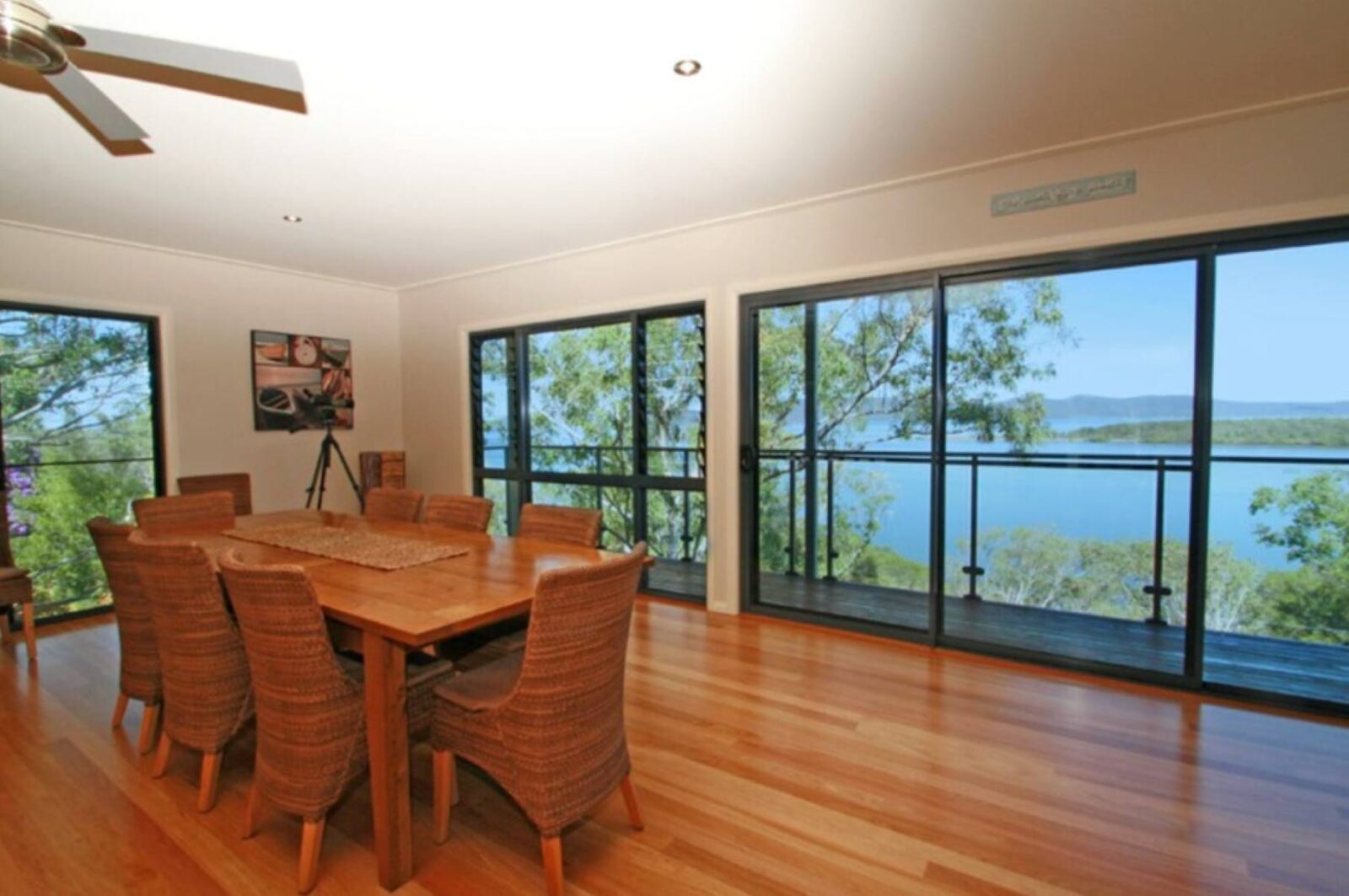 Dining room with 8 seater setting, ceiling fan and ocean views