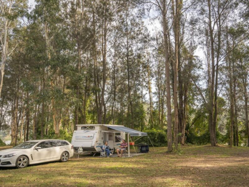 A couple sit outside their caravan at Cattai campground in Cattai National Park, on the Hawkesbury