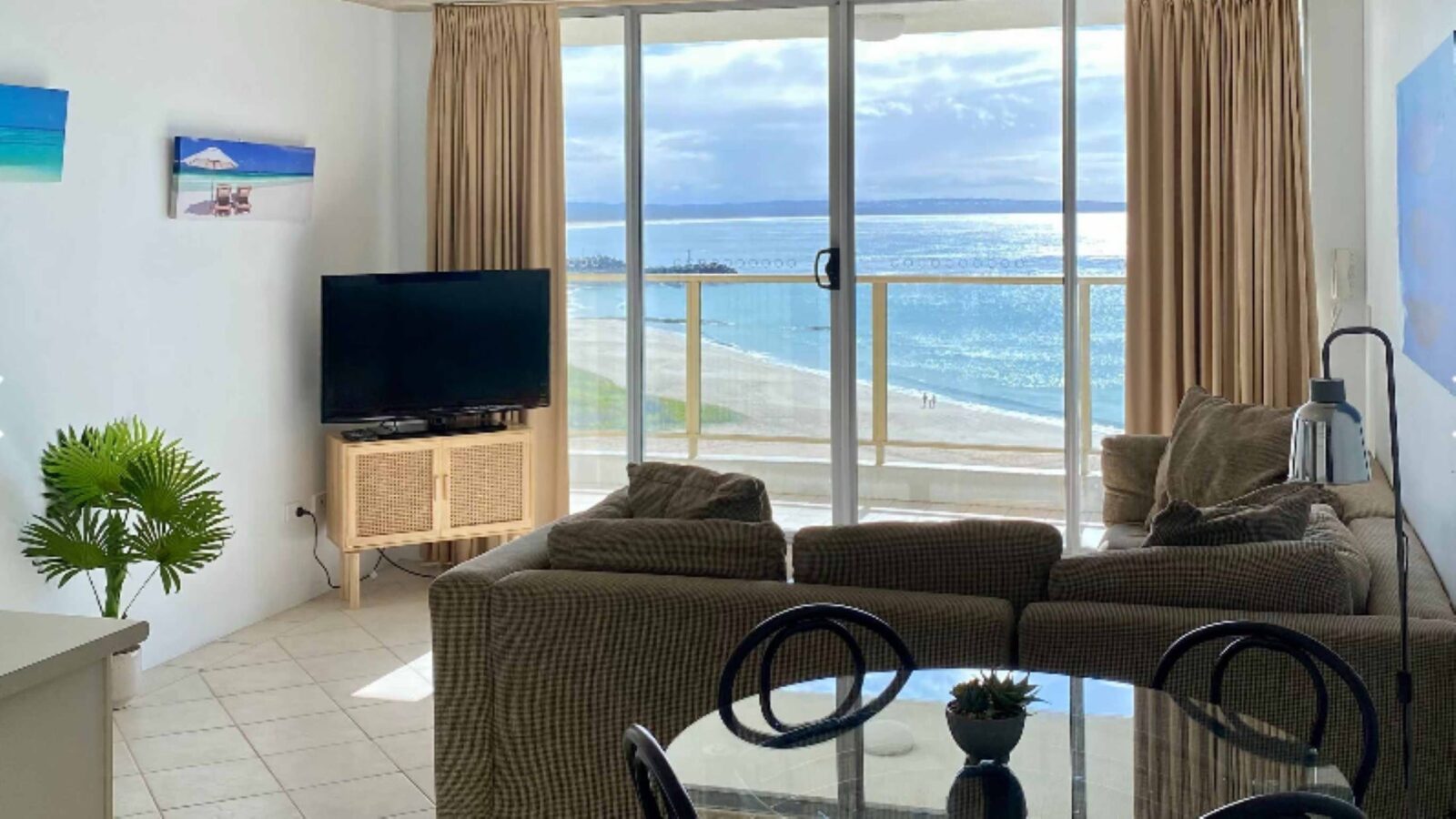 Lounge room with lounges, TV and stunning beach views